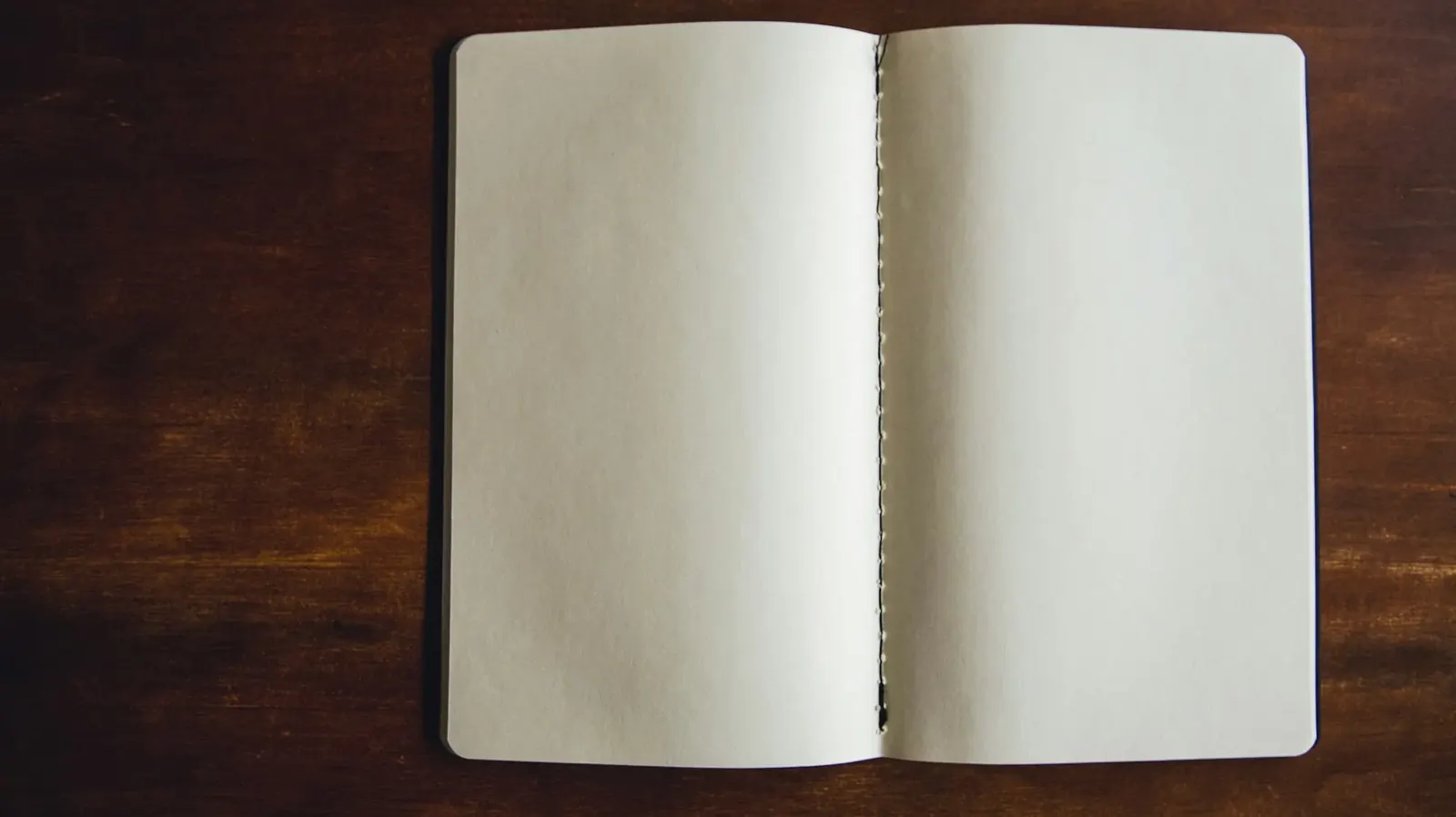 Open notebook on a dark wooden table