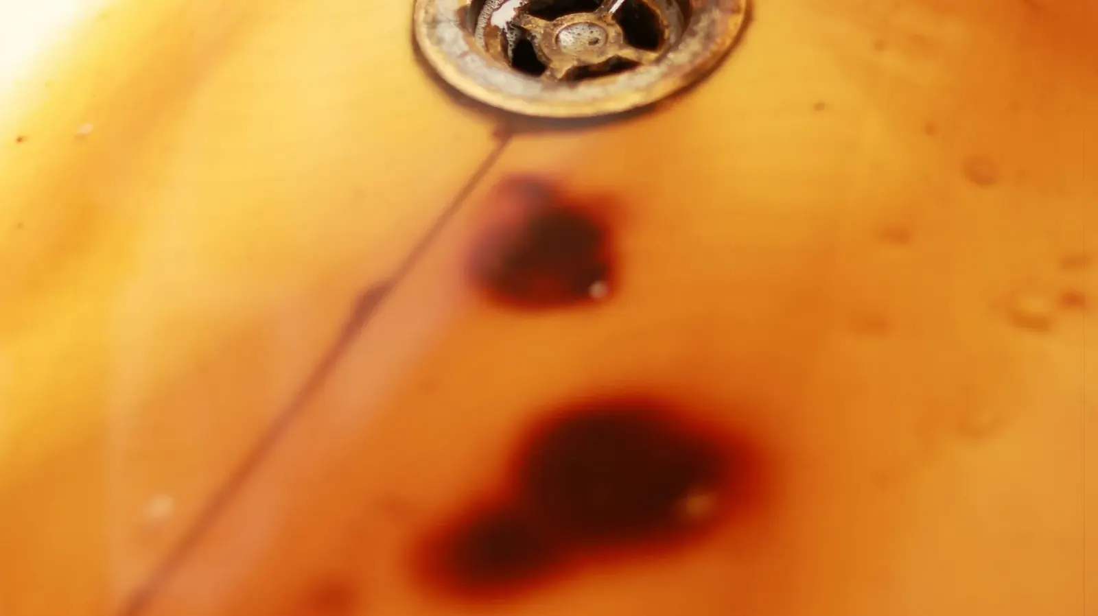 Rust-colored stain around a sink drain