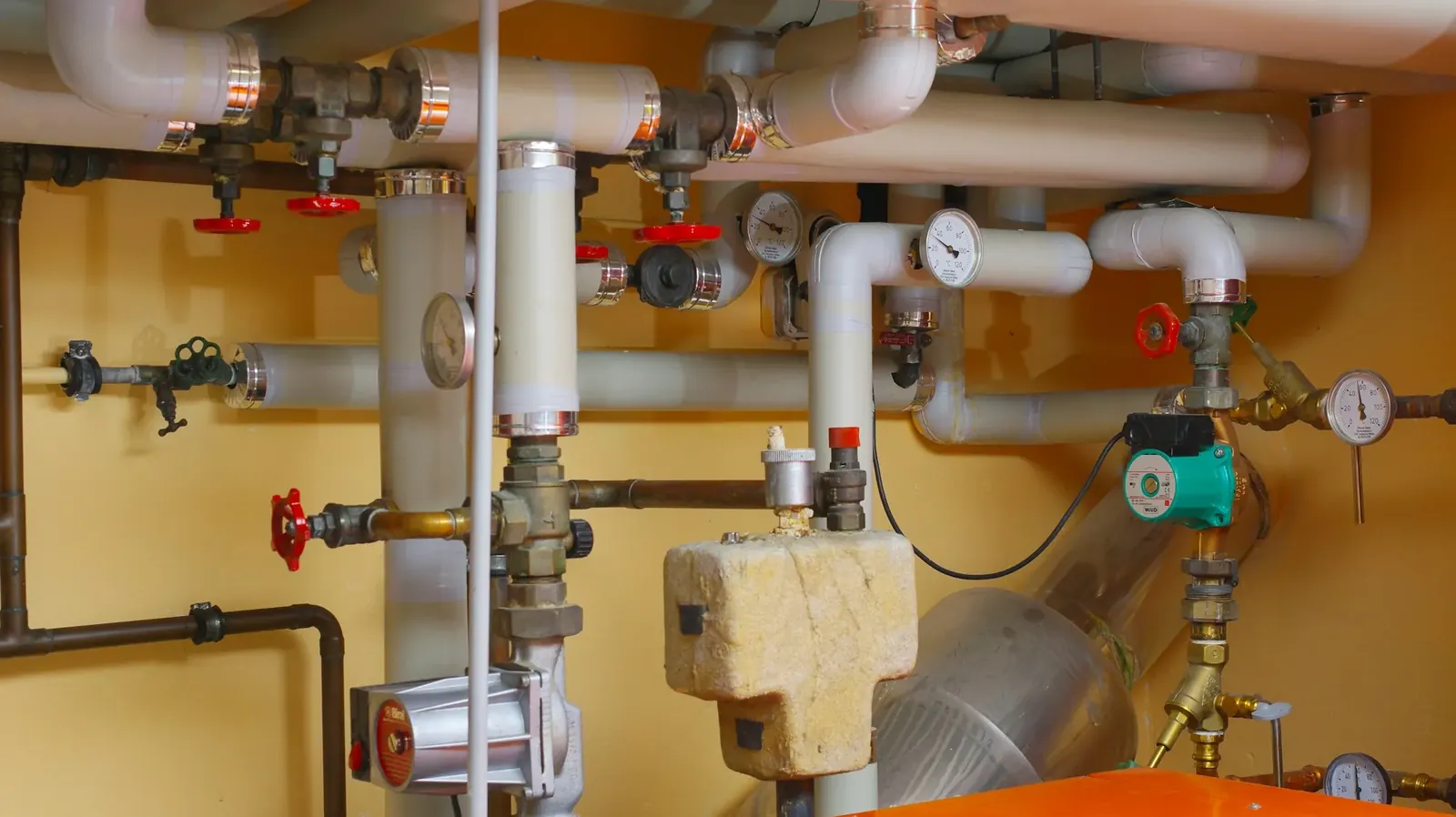 Pipes and valves along a utility room wall